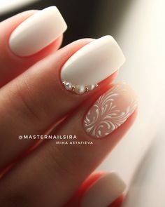 a woman's hand with white manies and pearls on the tip of her nails