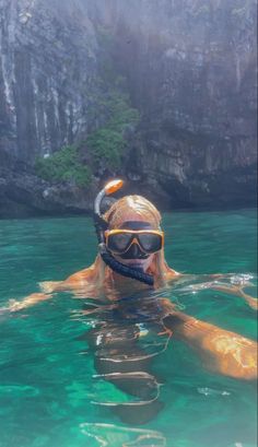 a man swimming in the water with goggles on his head and snorkels