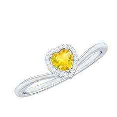 a heart shaped yellow sapphire and diamond ring with white diamonds on the band, set in 18k white gold