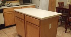 a kitchen with wooden cabinets and white counter tops in front of a refrigerator freezer