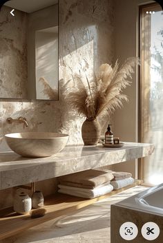 a bathroom with a sink and mirror next to a bathtub filled with towels on top of it