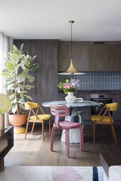 a dining room table and chairs with plants in vases on the top of them