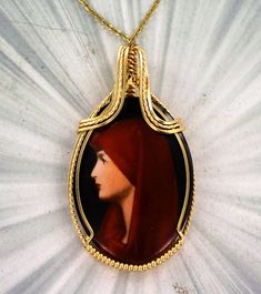 THE BEAUTY OF CAMEOS Amazing   2  inch   hand Painted  cameo  set in  14kt. Rolled Gold   ---- a one of a kind custom design. 40x30mm oval   shaped Cameo  with high detail which cannot be seen in the photograph.  The Cameo -- Intricate detail that you can see and notice The Cameo is  2  INCHES  LONG Very delicate and intricate in appearance and will get you noticed!   One of a kind handcrafted piece of jewelry that anyone will look good in Absolutely amazing something that you will be proud to wear You won't be disappointed with cameo pendant Cameo Jewelry, Cameo Necklace, Cameo Pendant, Be Proud, The Beauty, Jewelry Necklaces, Custom Design, Hand Painted, Pendant Necklace