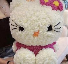 a white teddy bear made out of flowers