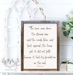 a wooden frame with a quote on it next to a potted plant and other items