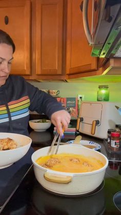 a woman is cutting into a bowl of soup with a knife and fork in it