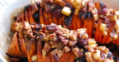 baked sweet potatoes with nuts and raisins in a white dish on a table