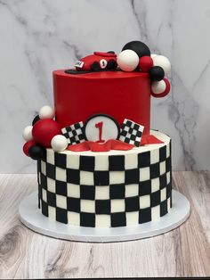 a red and white cake with black and white checkerboard design on the top