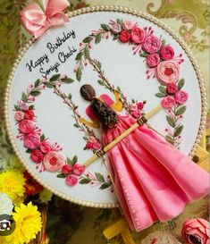 a birthday card with a pink dress and flowers