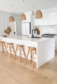 a kitchen with white cabinets and wooden stools