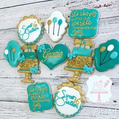 decorated cookies are arranged in the shape of heart, cake, and graduation decorations on a white wooden surface