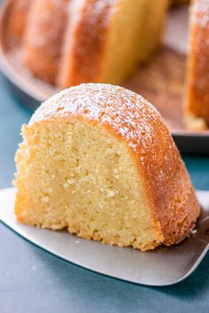 a bundt cake with powdered sugar on top sits on a plate next to another bundt cake