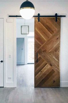 an open wooden door in the middle of a room with white walls and wood floors