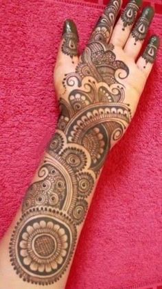 a woman's hand with henna tattoos on it