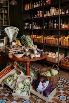 an assortment of fruits and vegetables in baskets on the floor next to shelves full of bottles