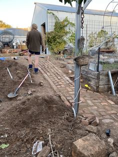 a man is walking in the dirt with shovels