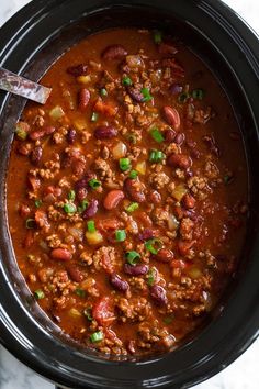 a crock pot filled with chili and beans