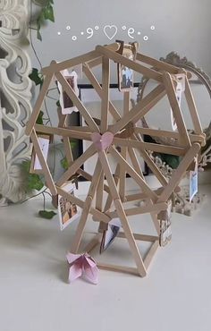 an origami ferris wheel with pictures attached to the sides and hearts on it