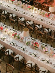 a long table is set up with flowers and place settings for an elegant wedding reception