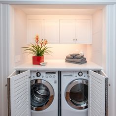 a washer and dryer in a room with white walls, wood floors and wooden flooring