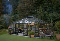 a glass house sitting on top of a lush green field