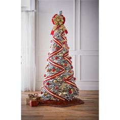 a white christmas tree with red and gold ribbons