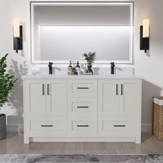 a bathroom vanity with two sinks and a large mirror over the sink, in front of a potted plant