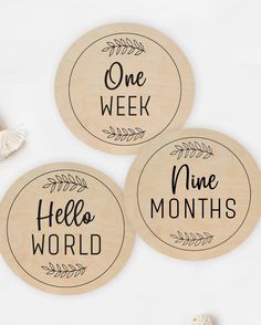 three wooden coasters with the words, one week and nine months printed on them