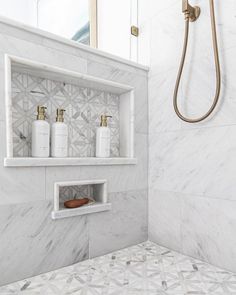 a bathroom with white marble and gold fixtures