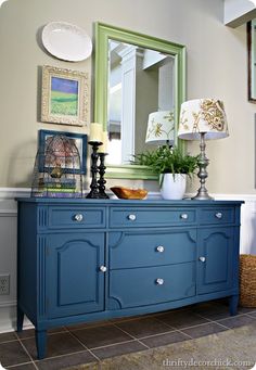 a blue dresser sitting in front of a mirror