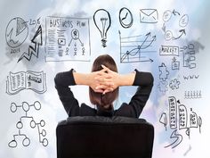 a woman sitting in a black chair with her hands on her head and drawings behind her