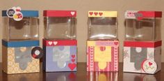 four small boxes sitting on top of a table next to each other with hearts in them