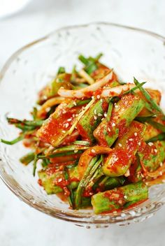 a glass bowl filled with vegetables covered in sauce