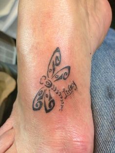 a small tattoo on the foot of a person with a butterfly in it's center