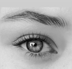 an eye with long lashes is shown in black and white