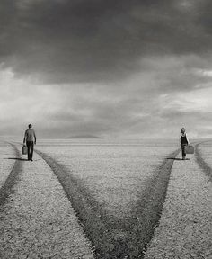 two people are walking in the middle of an empty field with double lines drawn on them