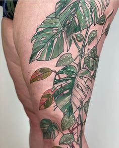 a close up of a person's thigh with plants on it and leaves in the background