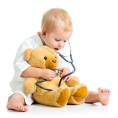 a baby sitting on the floor with a teddy bear in his lap and med galicja sa logo above it