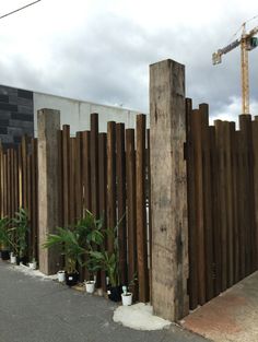 a wooden fence with potted plants next to it