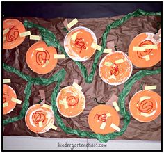 paper plate pumpkins with green leaves and orange circles cut out on brown tissue paper