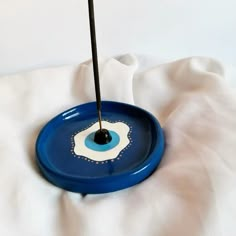 a blue and white object with a black stick sticking out of it's center