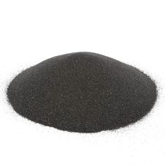 a pile of black sand sitting on top of a white surface