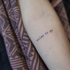 a woman's arm with the words miles to go tattooed on her left arm