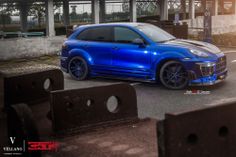 a blue porsche cayen is parked on the street