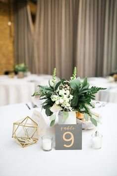 the table is set up with white flowers and greenery