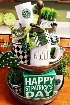 a cup filled with lots of green stuff on top of a wooden table next to a plant