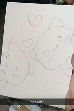 someone is drawing two cats on paper with pencils