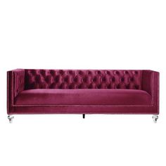 a red velvet couch with metal legs and buttons on the back, in front of a white background