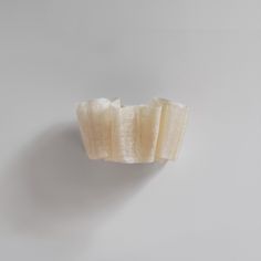 a piece of banana sitting on top of a white wall