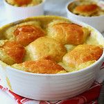 three small white bowls filled with food on top of a red and white napkin